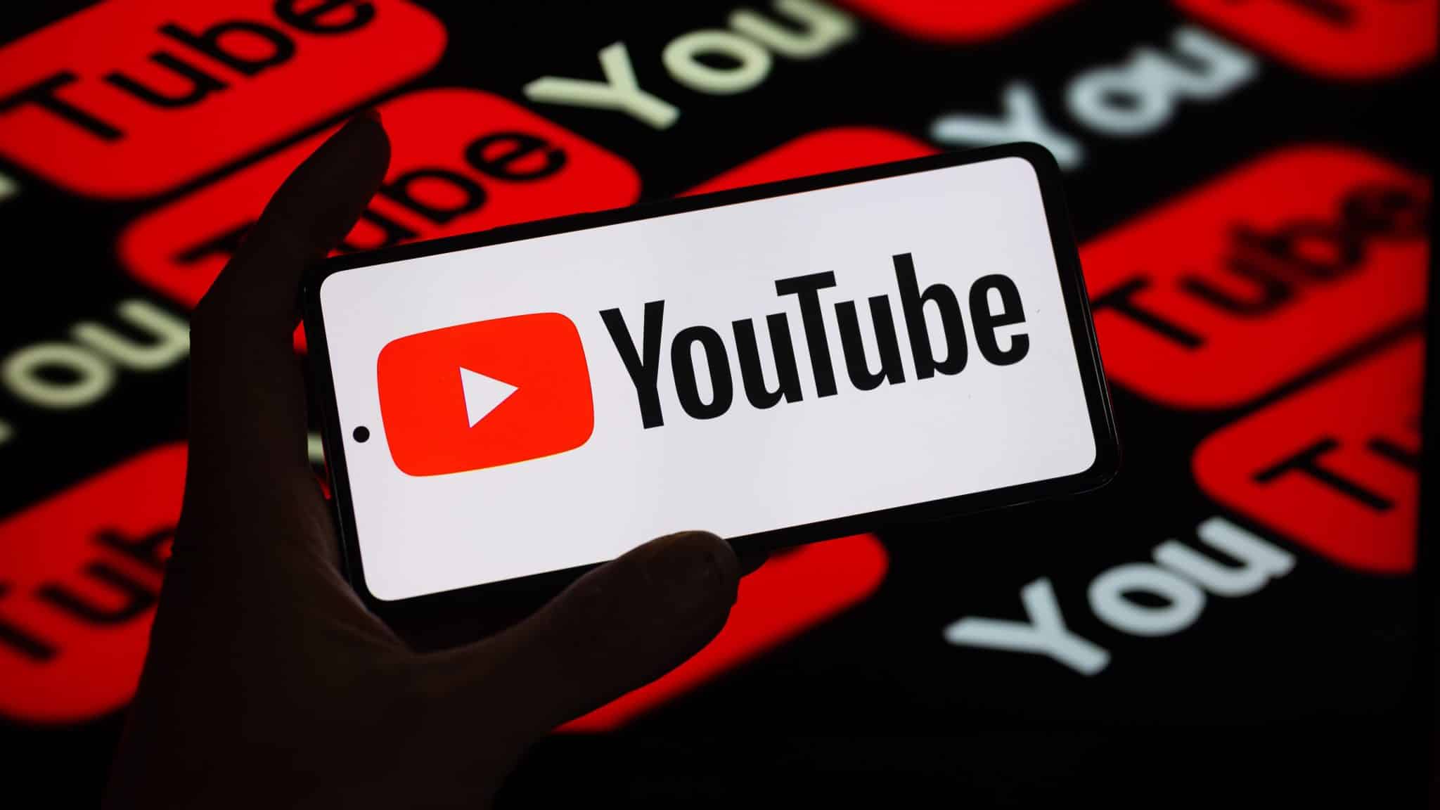 YouTube-Logo auf dem Bildschirm vor anderen YouTube-Logos auf schwarzem Hintergrund