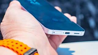 手持角度的三星 Galaxy S25 顯示螢幕底部和帶有 SIM 卡託的 USB-C 端口