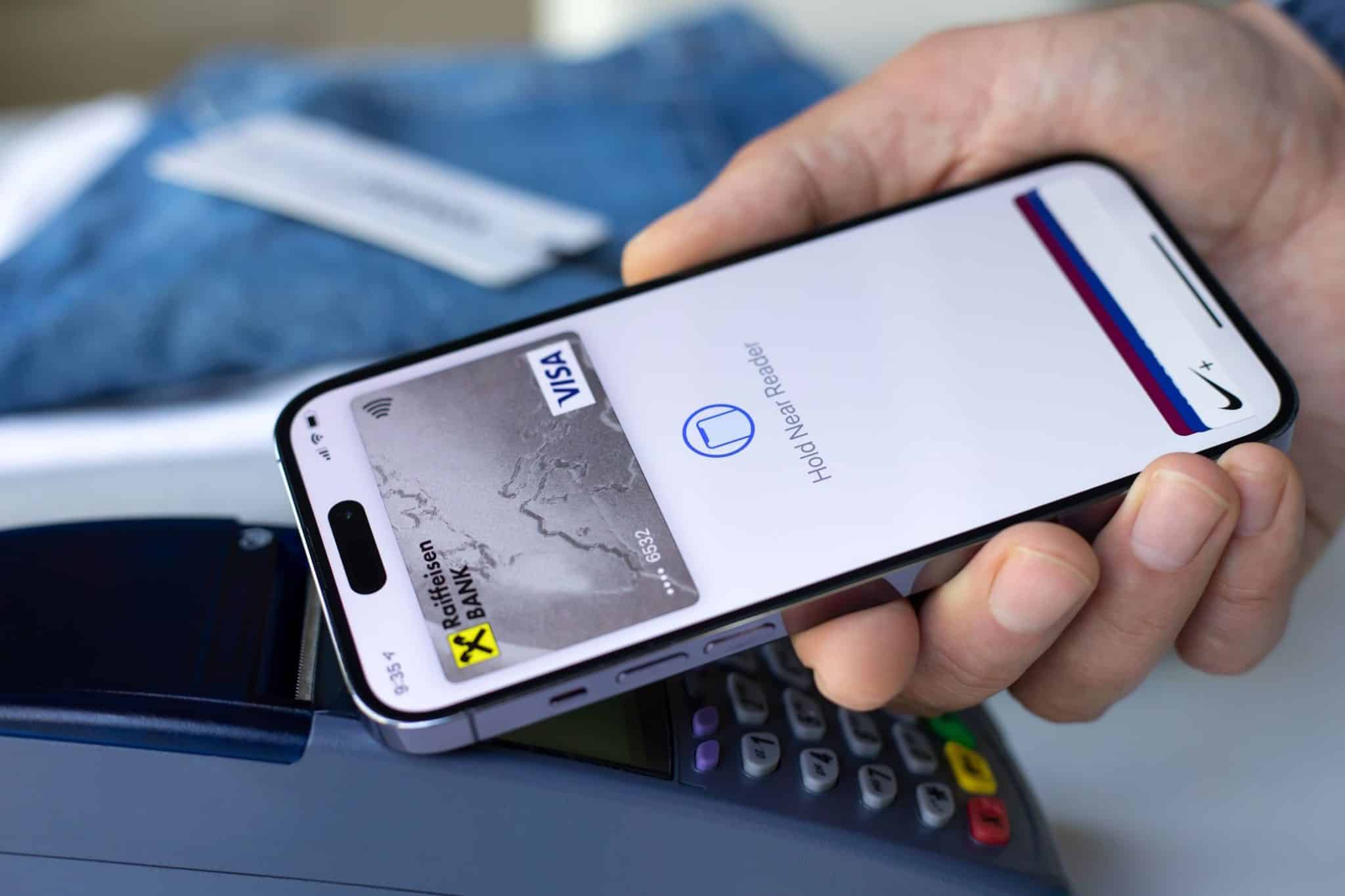 Un homme utilise Apple Pay sur son iPhone pour effectuer une transaction