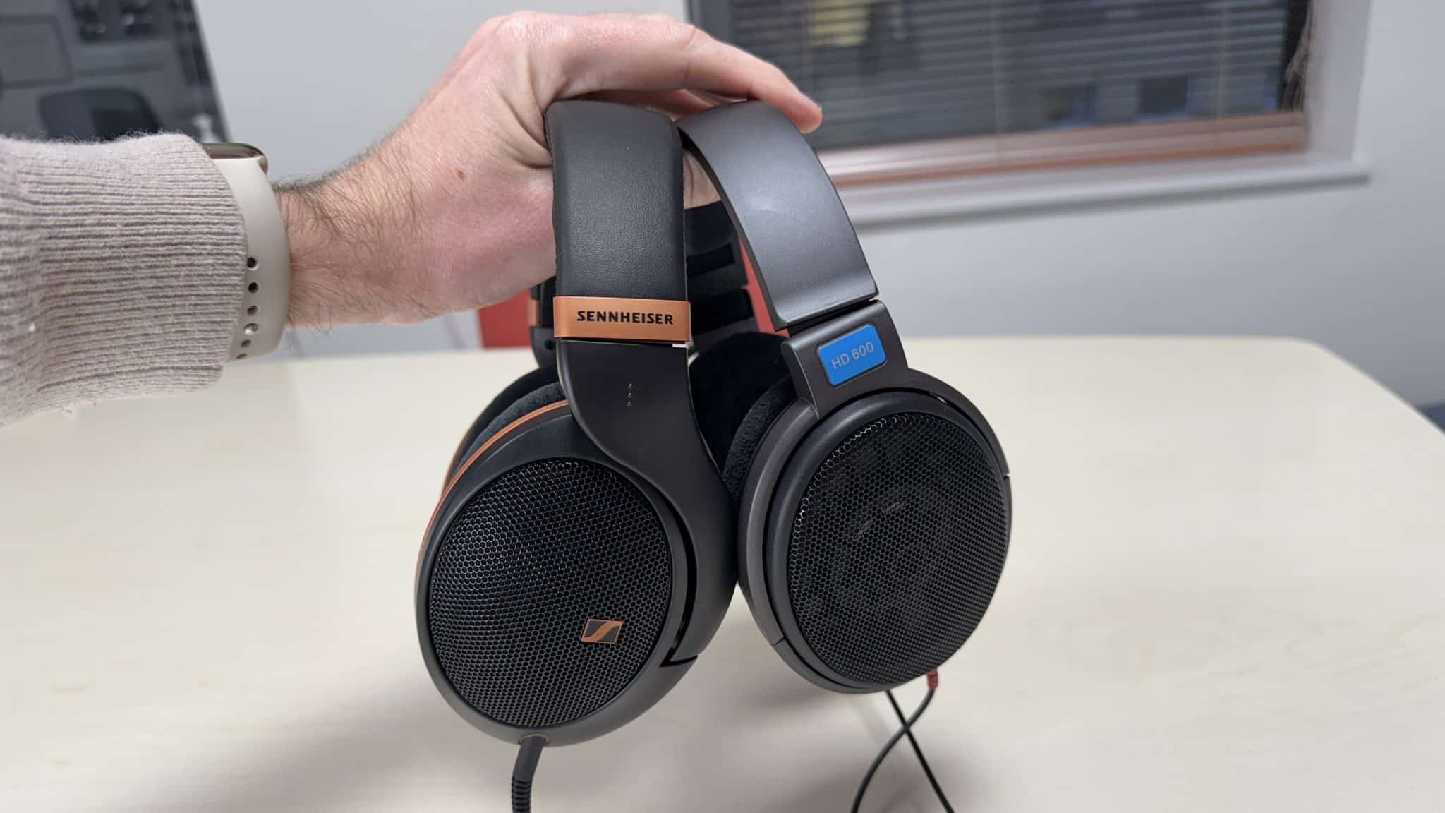 一位男士手中拿著 Sennheiser HD 505 和 HD 600 耳機