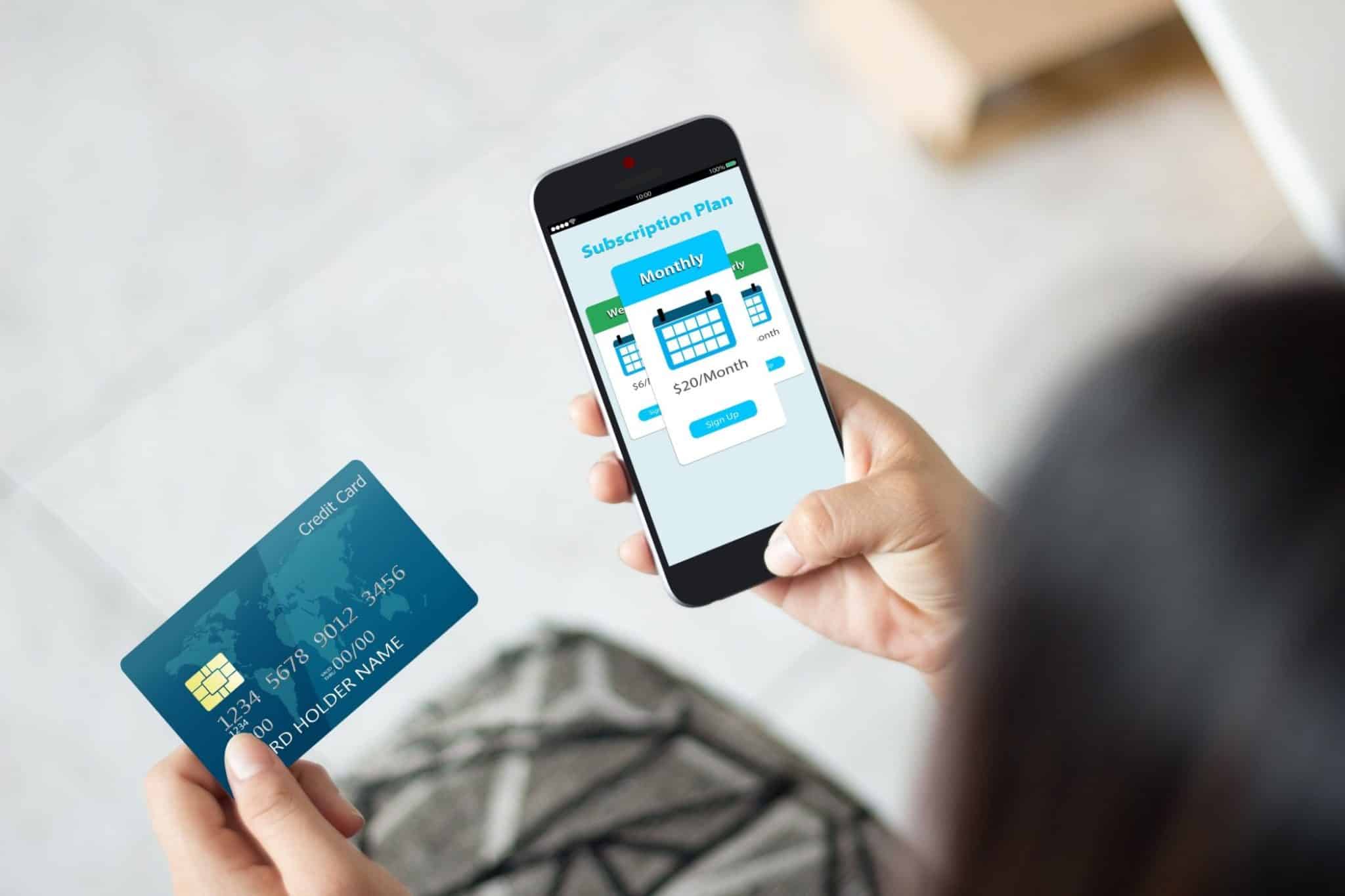 Personne utilisant une carte de crédit pour acheter un abonnement sur son téléphone