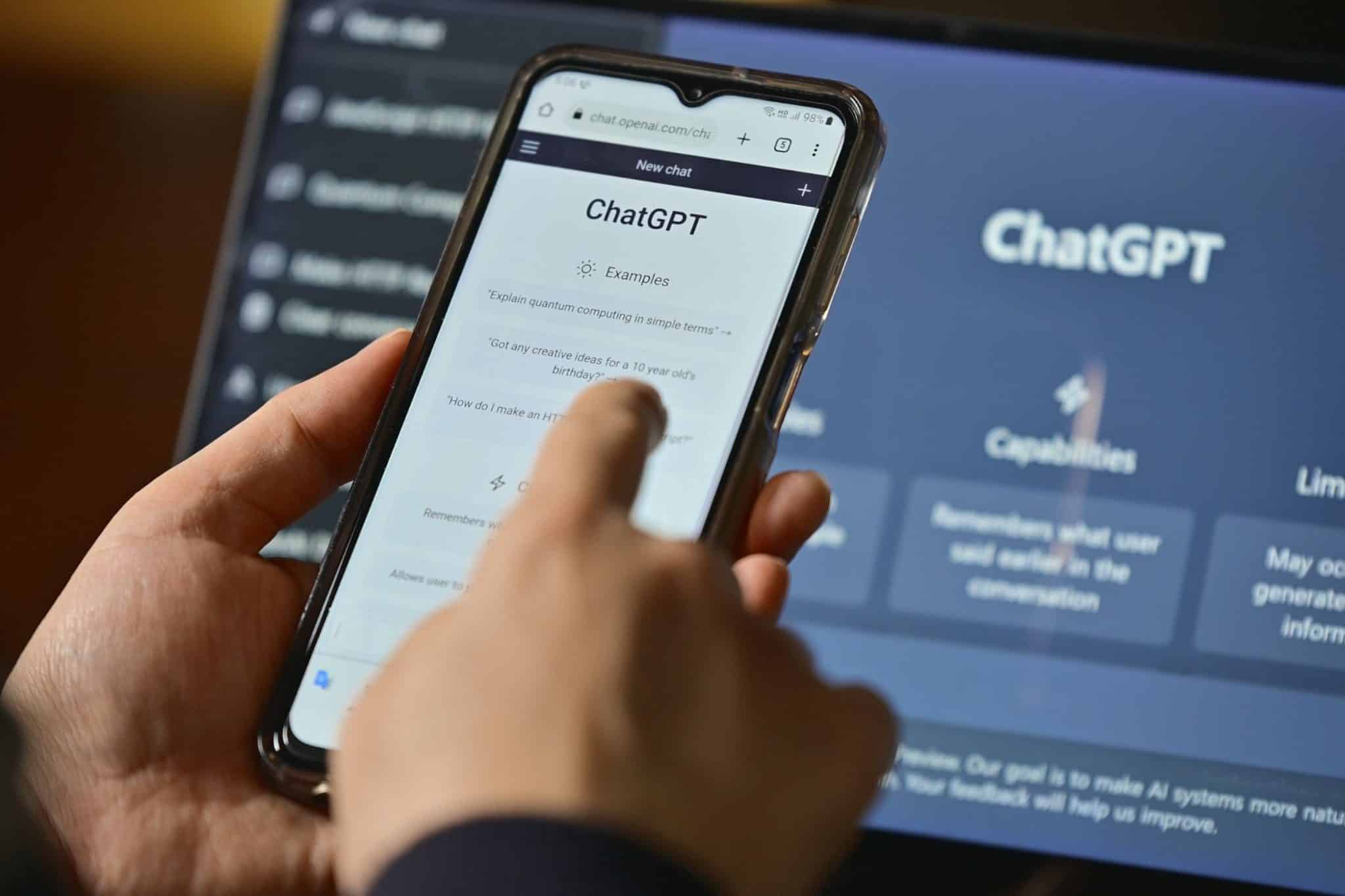 quelqu'un utilisant chatgpt sur son smartphone et son ordinateur portable