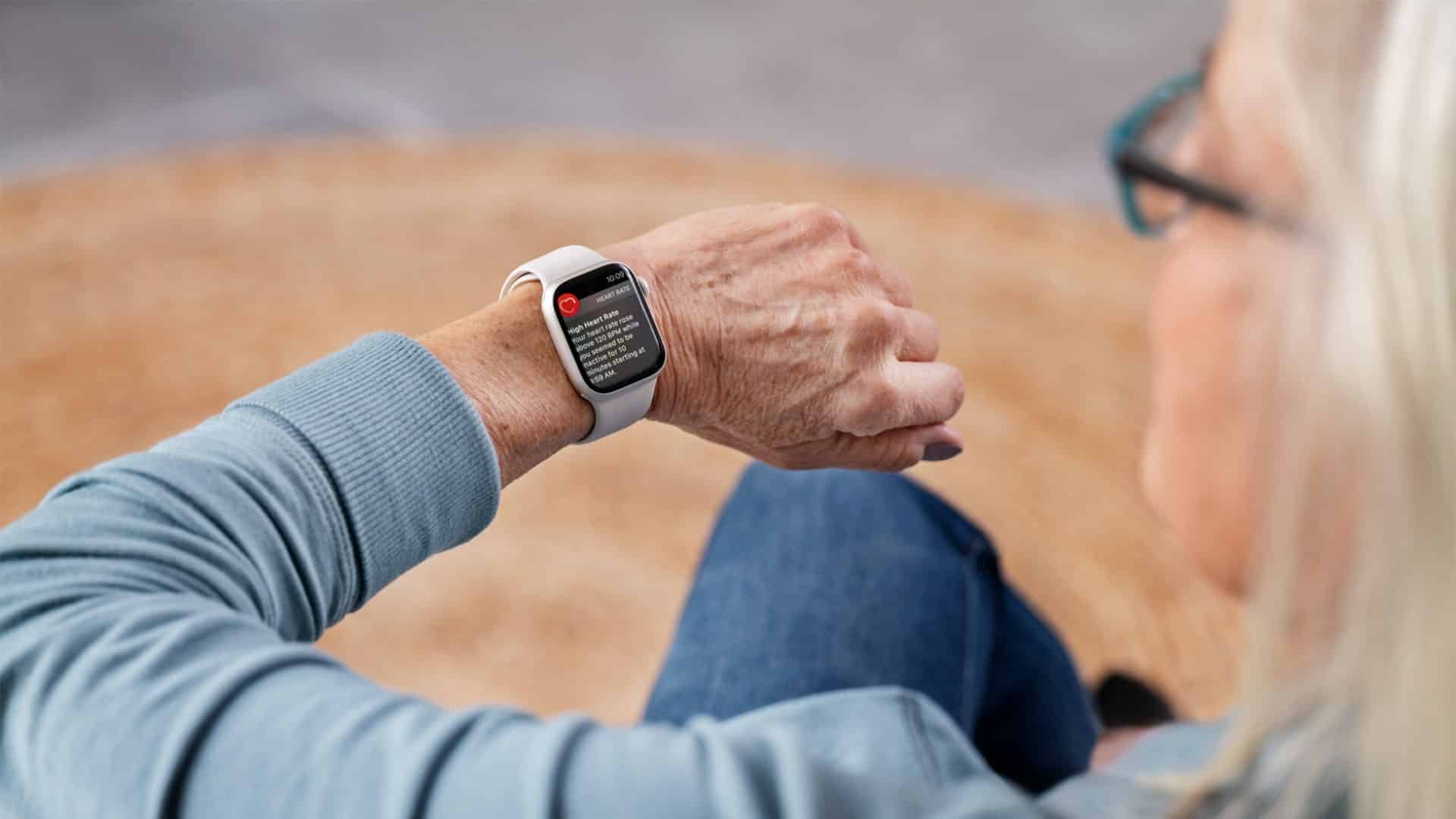 Ένα άτομο κοιτάζει ένα Apple Watch στον καρπό του. Η συσκευή τον προειδοποιεί για αυξημένο καρδιακό ρυθμό.