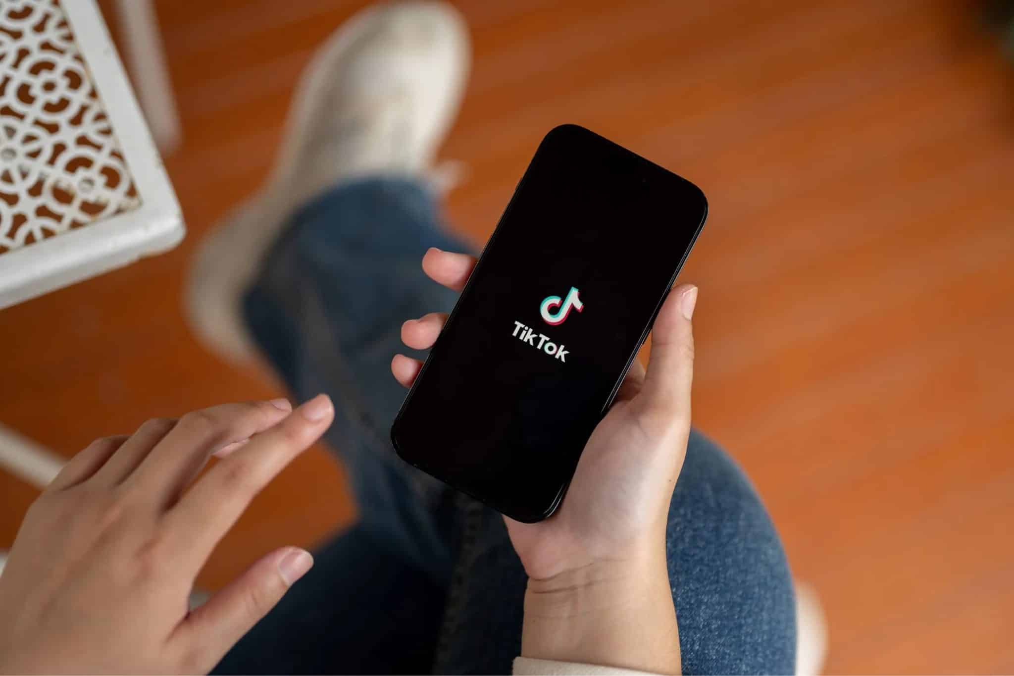 一個人拿著裝有 TikTok 應用程式的智慧型手機