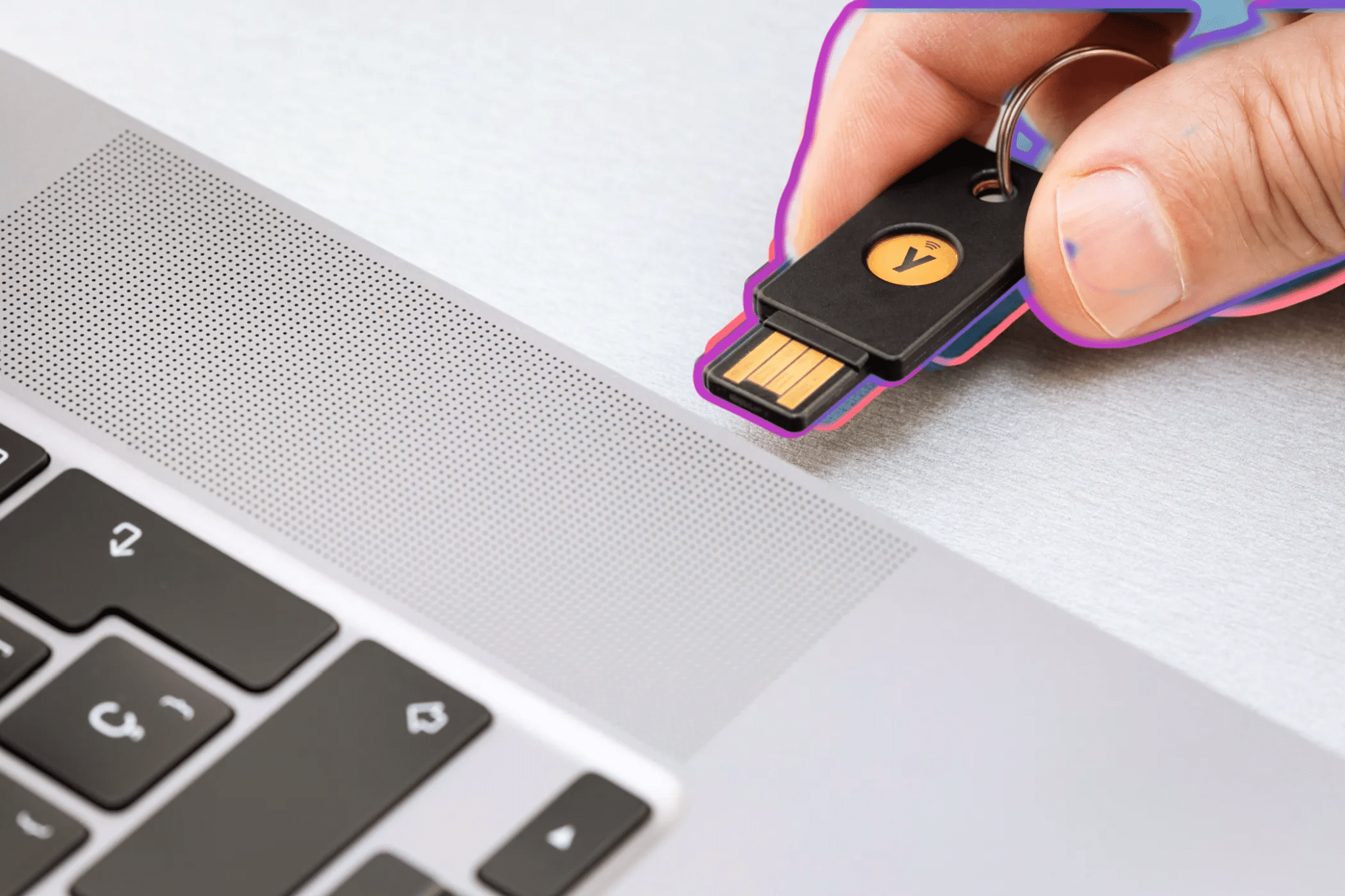 Una persona inserisce una chiave di sicurezza Yubico fisica nella porta USB di un computer portatile.
