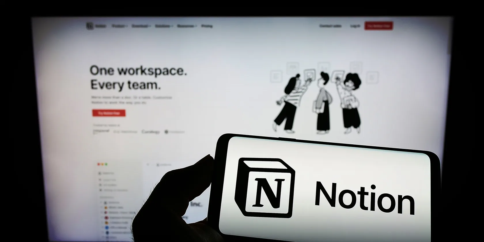 一部手機和一台顯示 Notion 介面和標誌的顯示器
