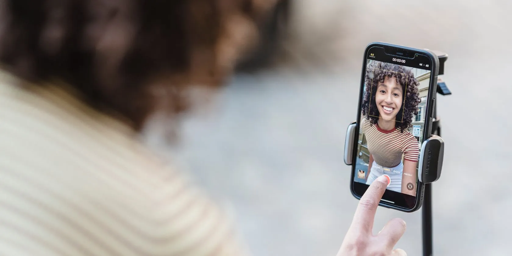 Kadın, sabitlenmiş akıllı telefonuyla kendini kaydediyor