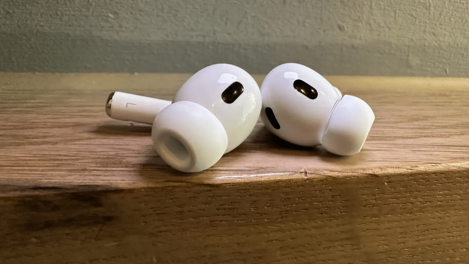 AirPods Pro 2 خارج علبتها على سطح خشبي