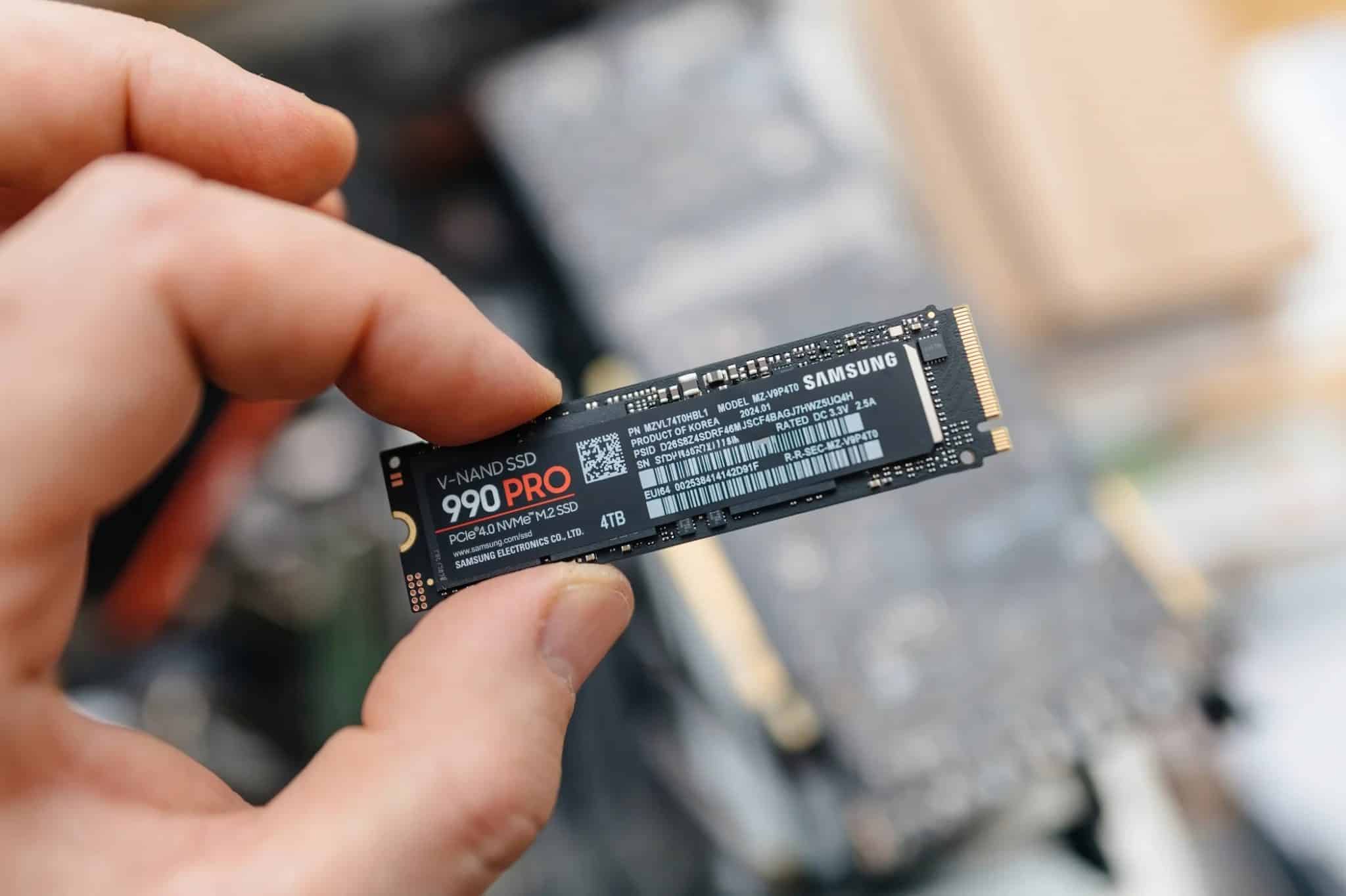 Un uomo tiene in mano un SSD Samsung 990 Pro.
