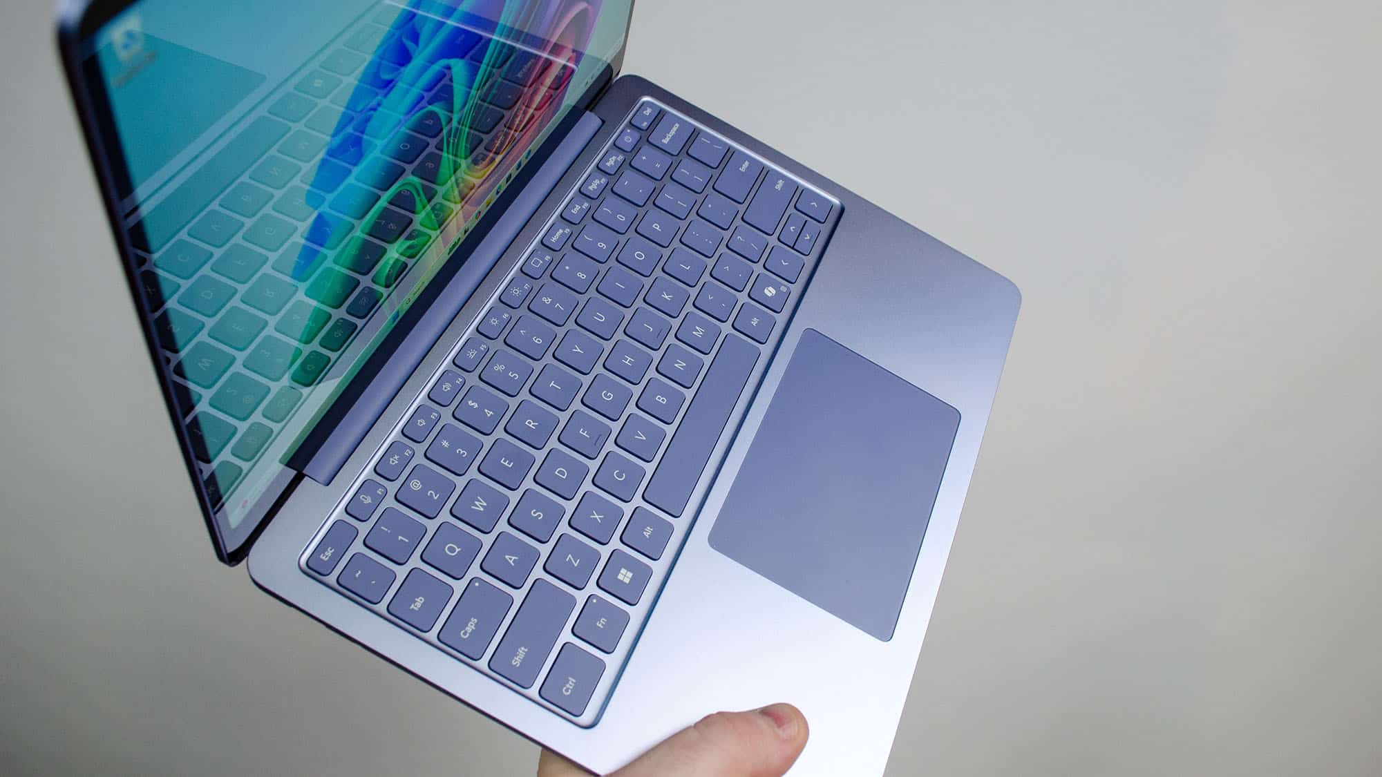 Una mano masculina sosteniendo la Microsoft Surface Laptop de 13 pulgadas en ángulo
