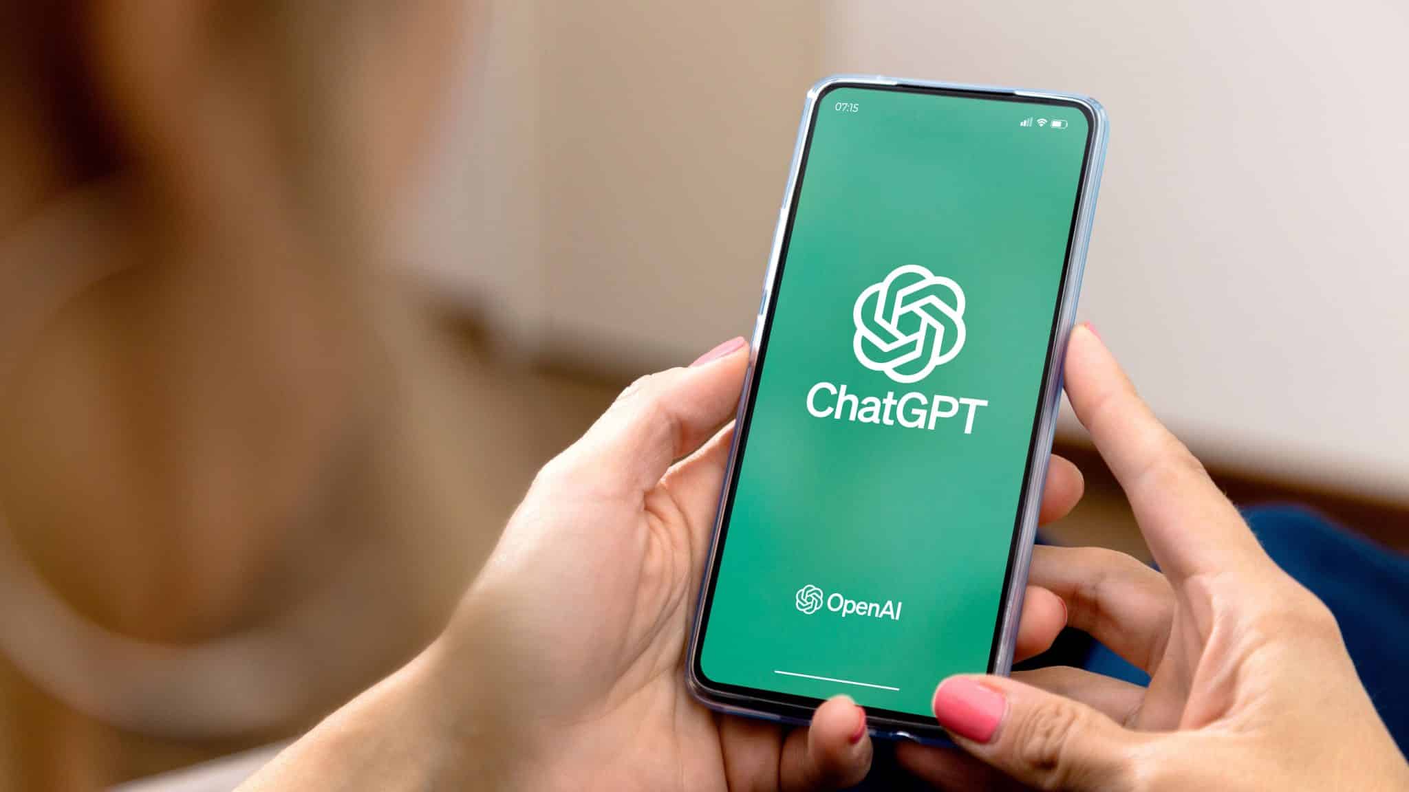Una donna utilizza un telefono cellulare con ChatGPT visualizzato sullo schermo.