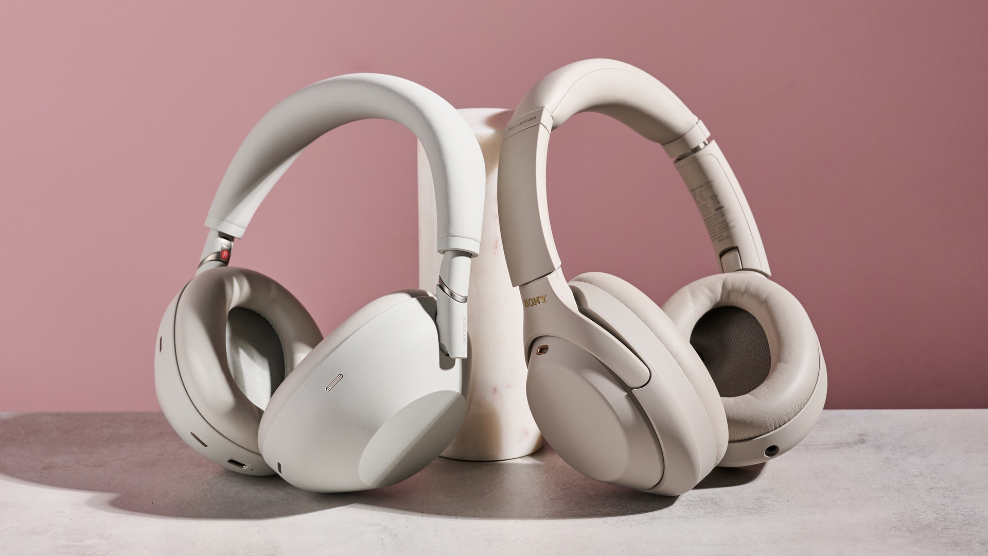 Sony WH-1000XM6 και Sony WH-1000XM4, και τα δύο ακουμπούν σε κυλινδρικό στύλο