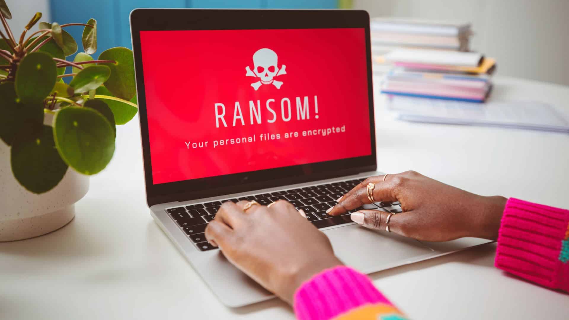 Üzerinde beyaz bir kafatası bulunan ve kırmızı ekrana sahip bir dizüstü bilgisayar ve şu mesaj: "RANSOMWARE. Tüm dosyalarınız şifrelendi."