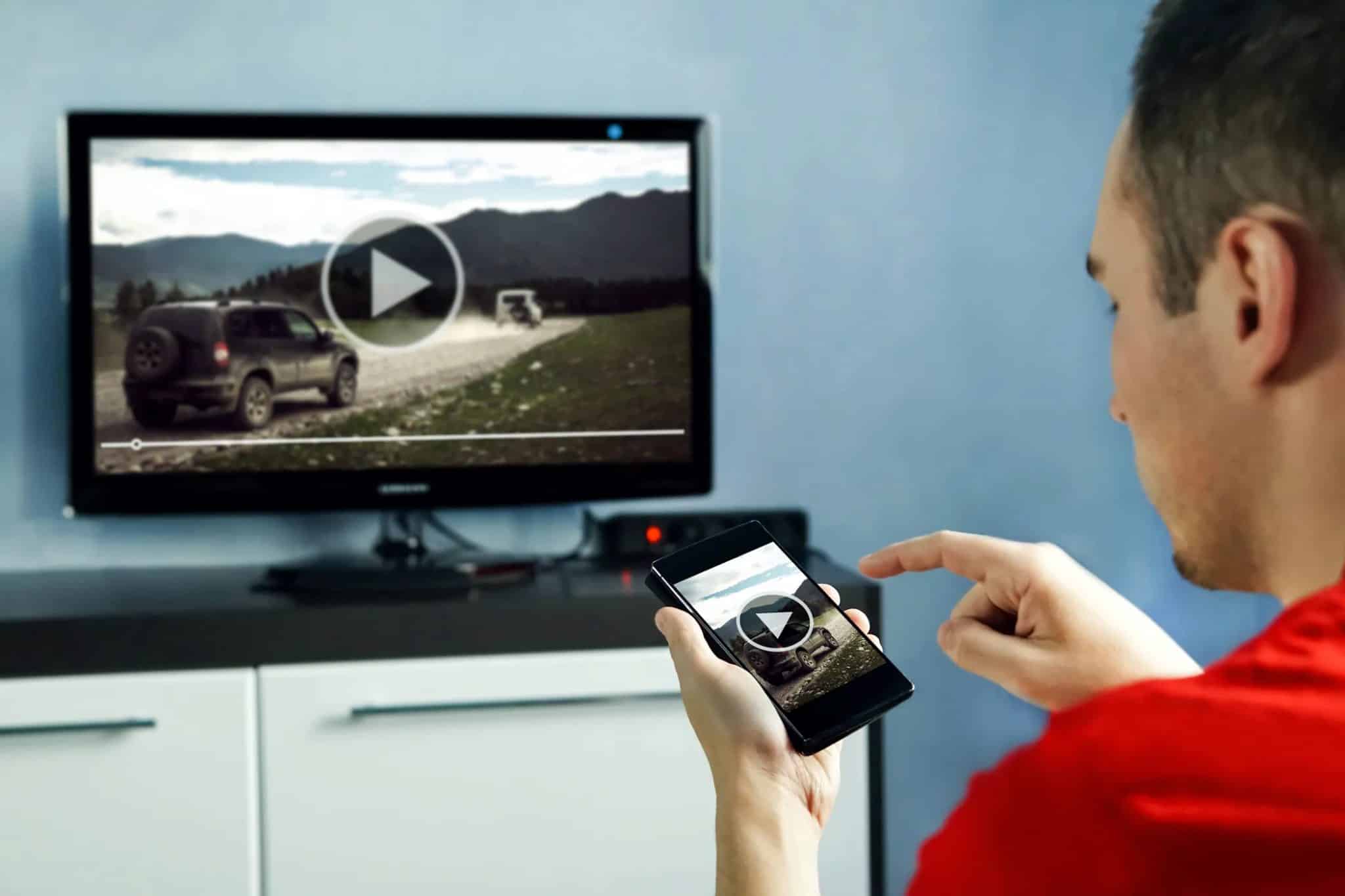 Mężczyzna ogląda film na telewizorze Smart TV za pomocą towarzyszącej mu aplikacji.