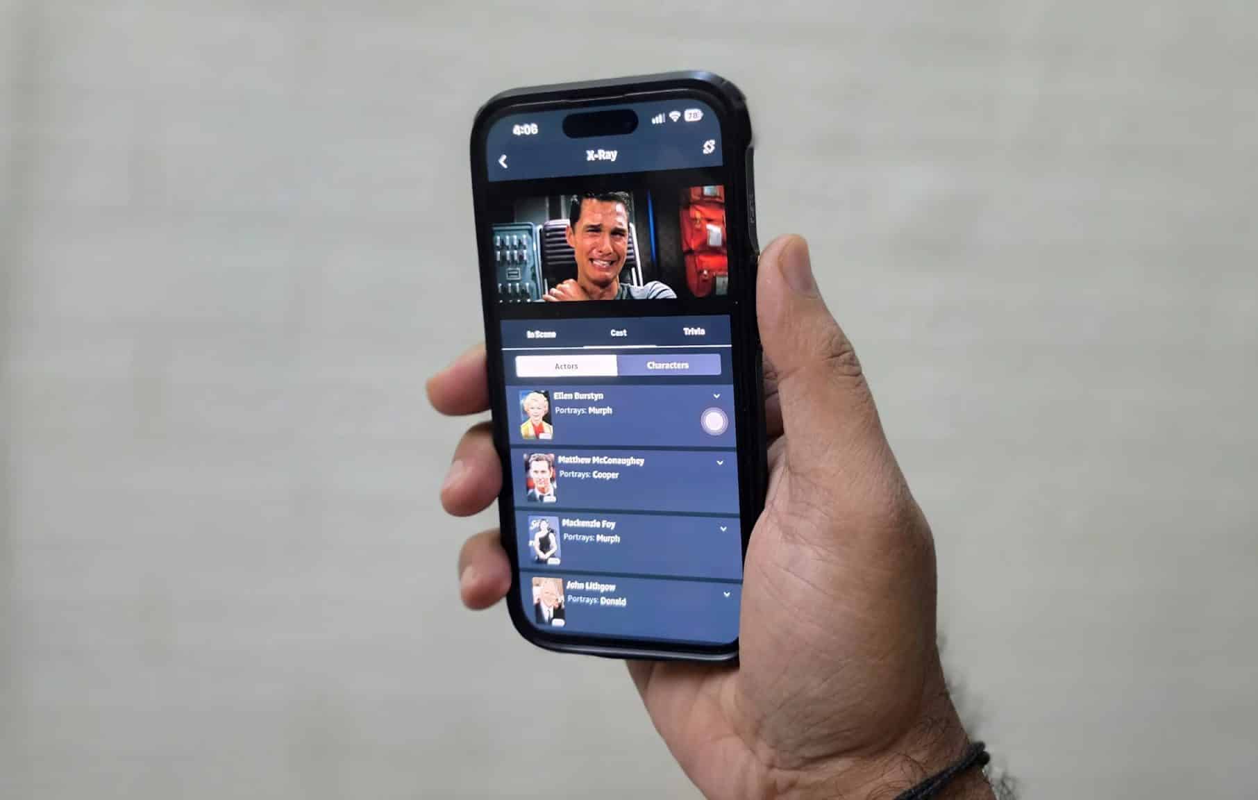 رجل يحمل هاتف iPhone ويشاهد فيلم Interstellar على Prime Video
