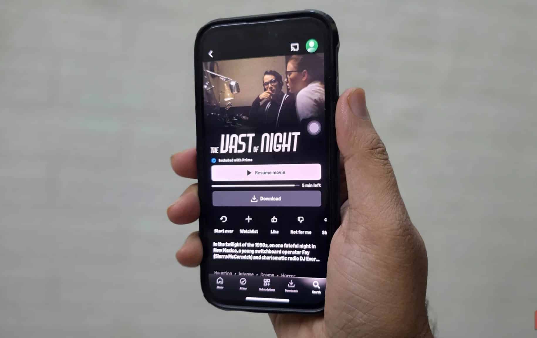 Ein Mann mit einem iPhone sieht sich „The Vast of Night“ auf Prime Video an.