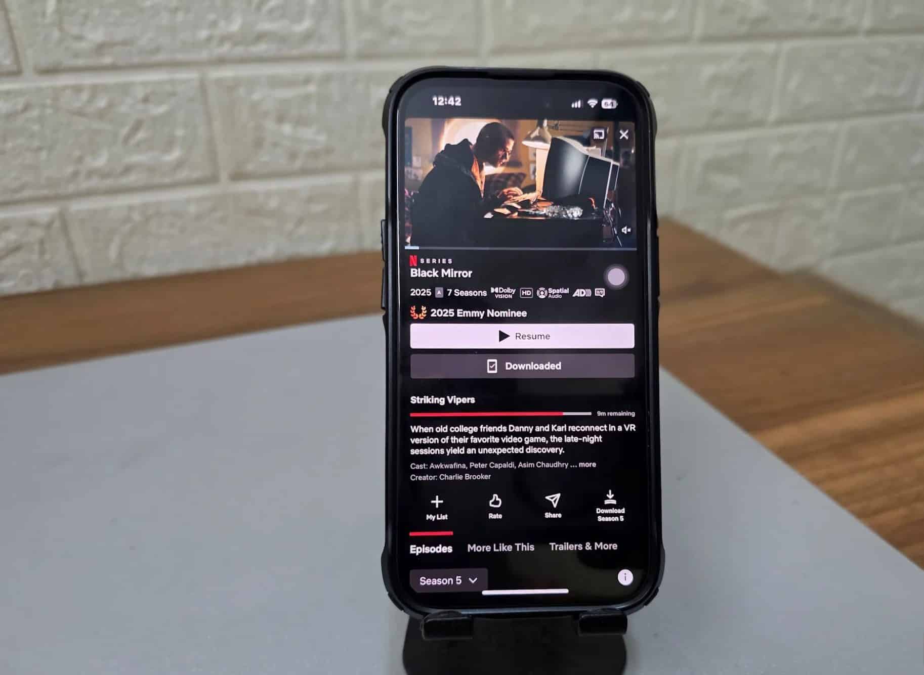 手機支架上放置著一部已開啟 Netflix 的 iPhone