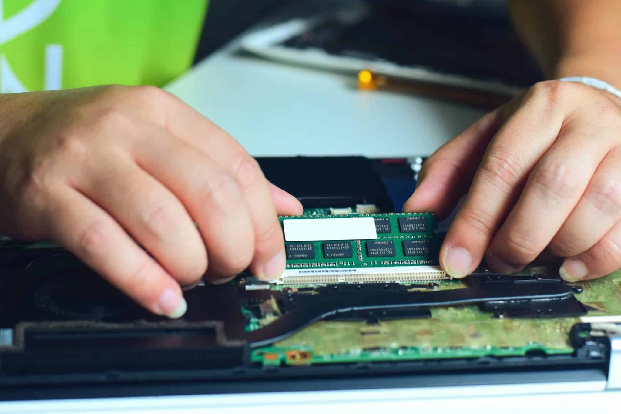 فني يقوم بتبديل ذاكرة الوصول العشوائي (RAM) في جهاز كمبيوتر محمول