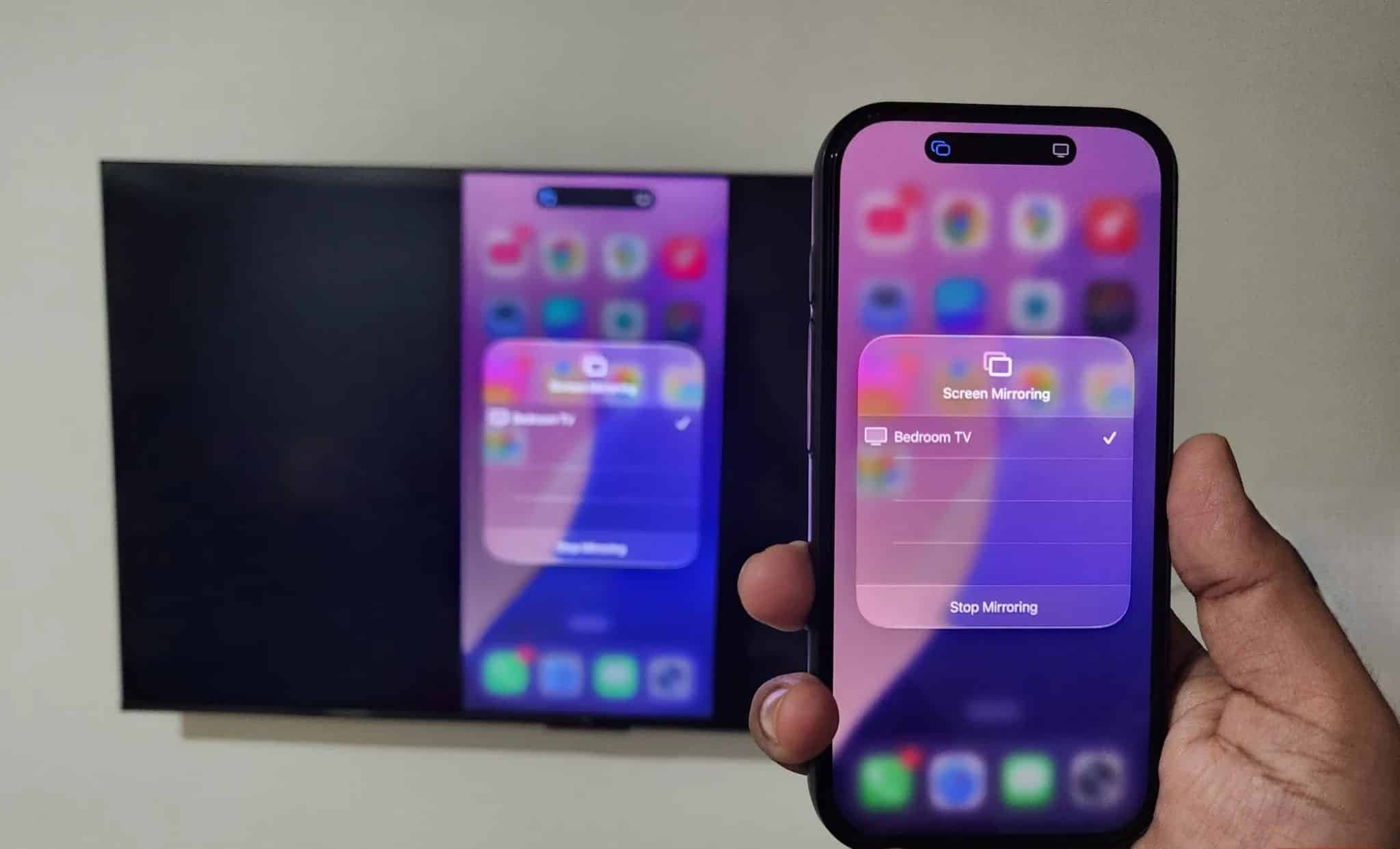 iPhone in hand mirroring screen to TV