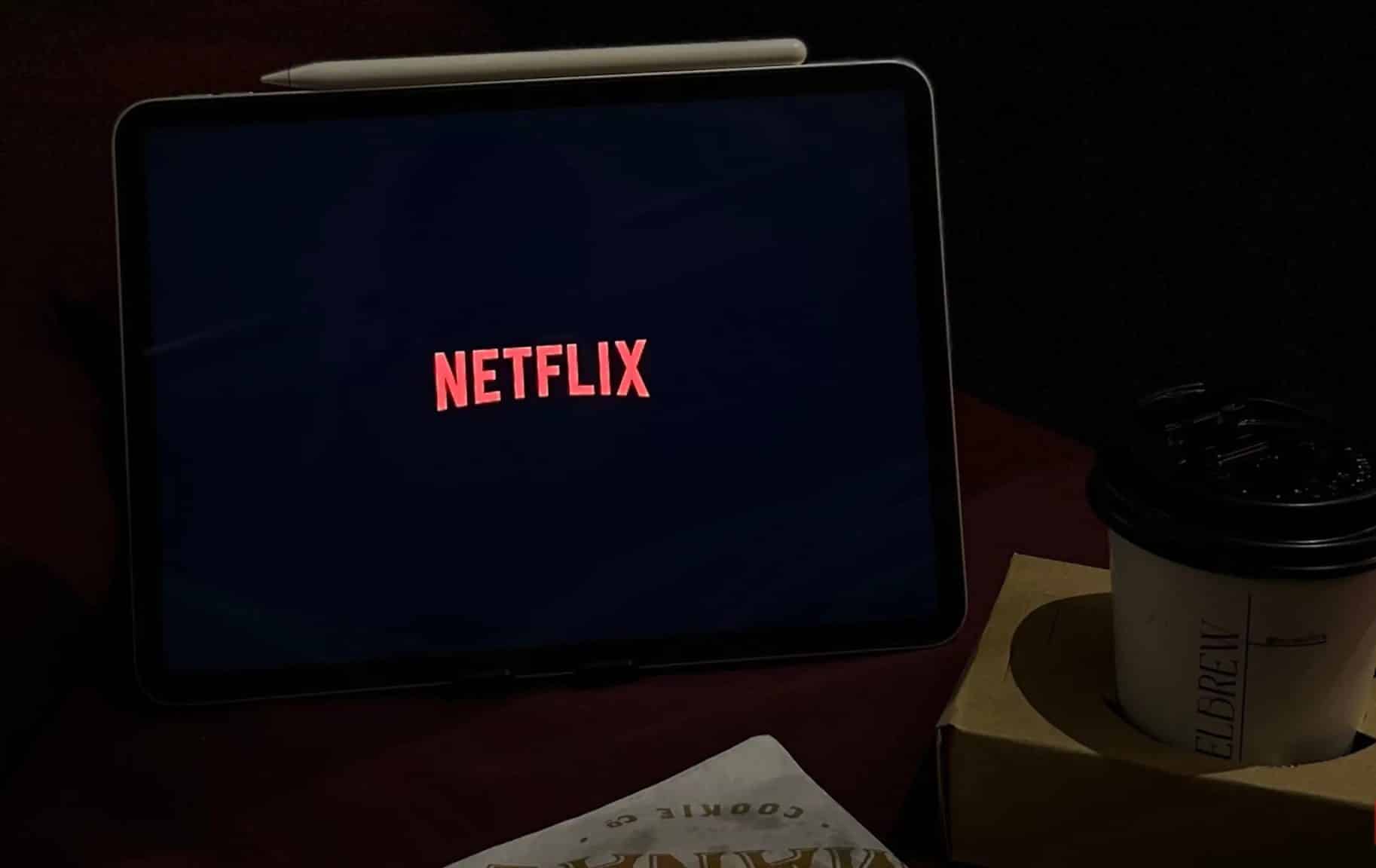 شاشة Netflix على جهاز iPad بجوار فنجان قهوة