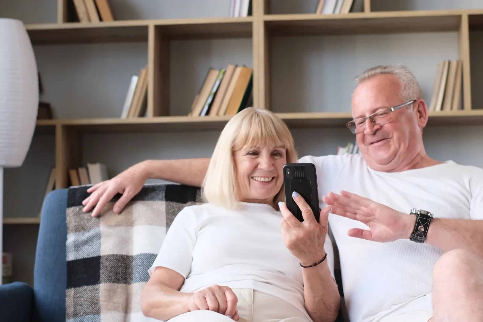 Um casal de idosos fazendo uma videochamada em seus telefones