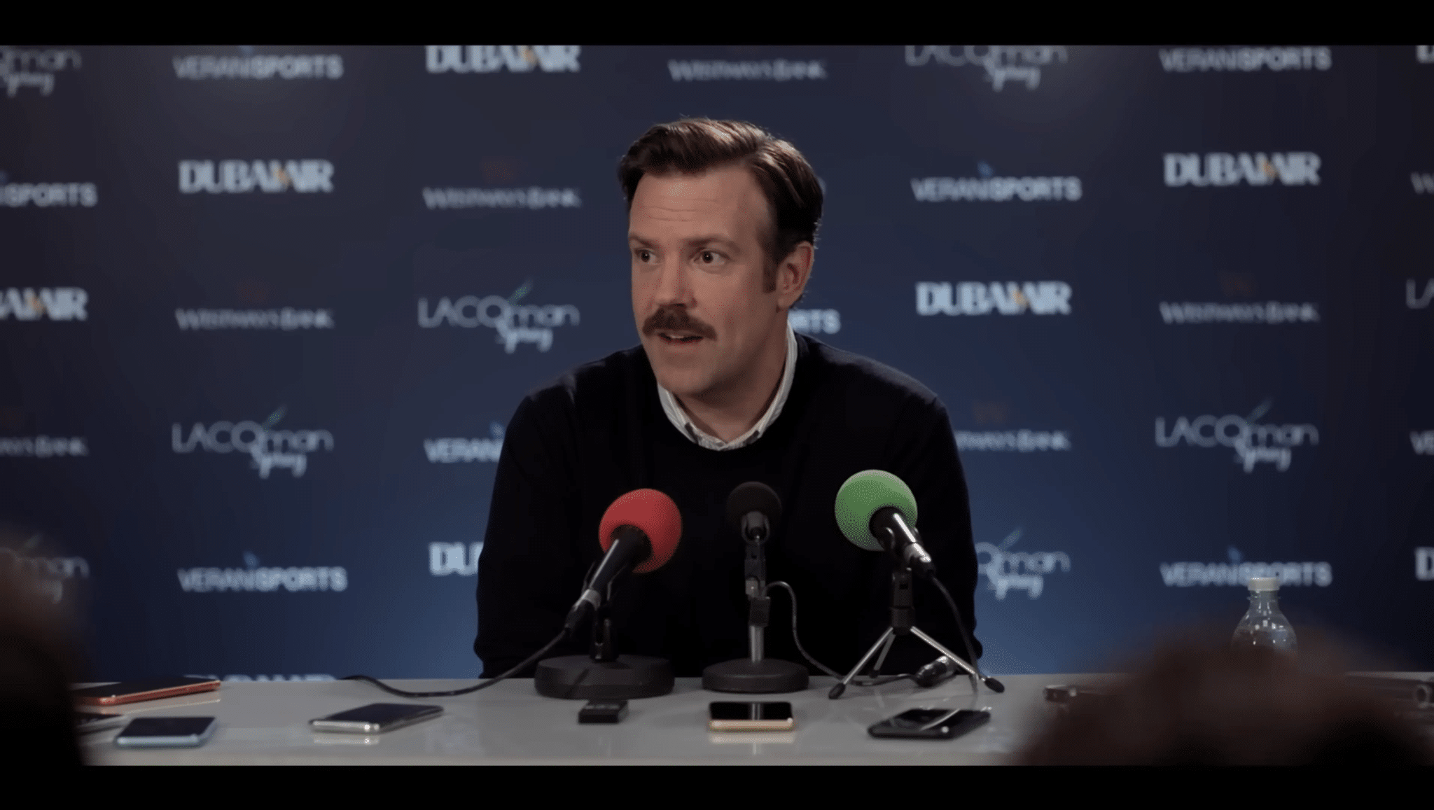 Jason Sudeikis di Ted Lasso sorride durante una conferenza stampa.