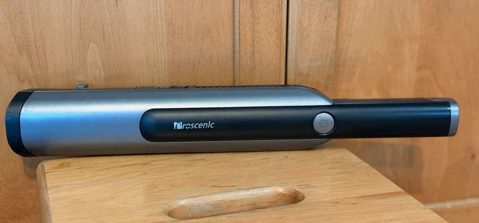 A black hand-held vaccum sitting on a surface.