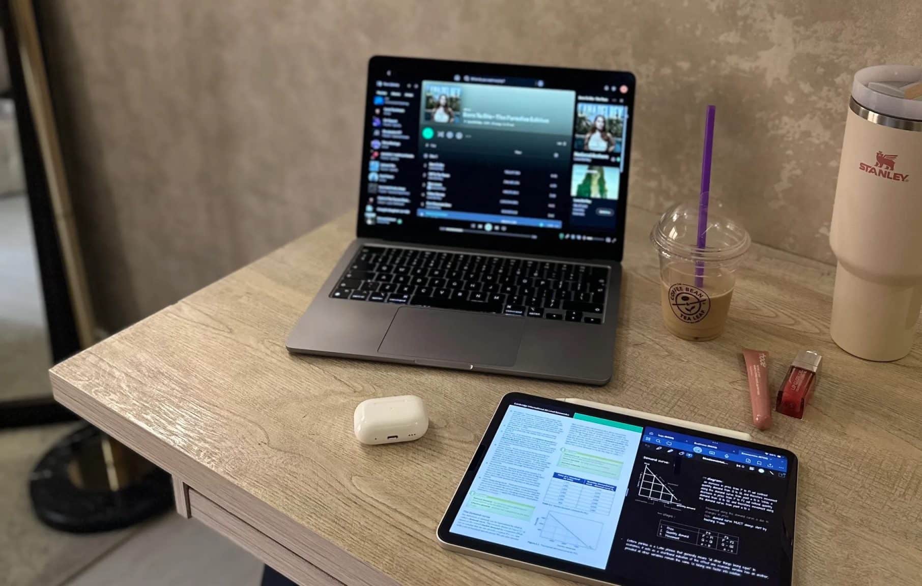 桌上放著 Mac 和 iPad,旁邊是 Stanley 和咖啡杯