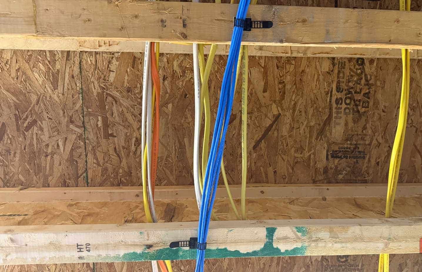 幾條 Cat6 電纜連接到地下室天花板的地板托樑底部。