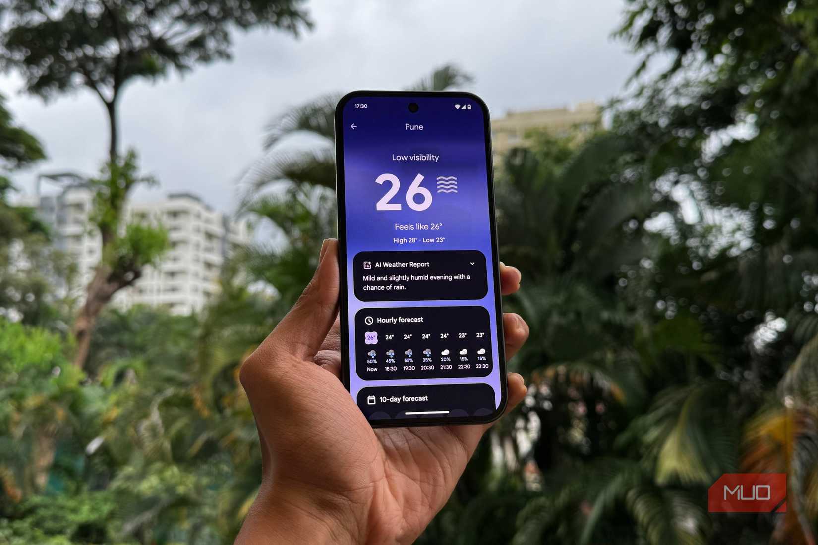 رجل يحمل Pixel 9 يعرض تطبيق الطقس وتقرير تم إنشاؤه بواسطة الذكاء الاصطناعي