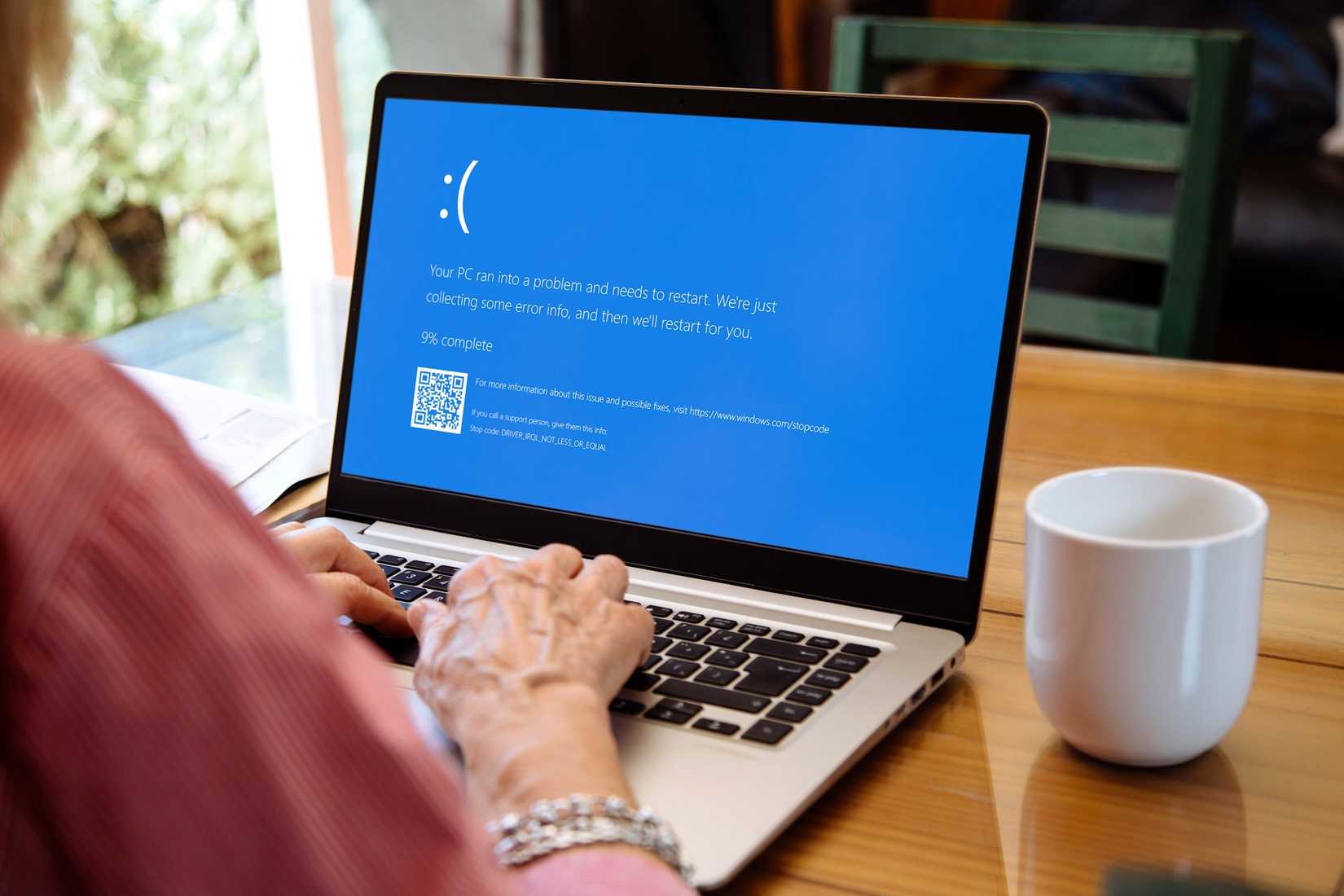 Su un portatile Windows appare una schermata blu di errore mentre è in uso da una donna.