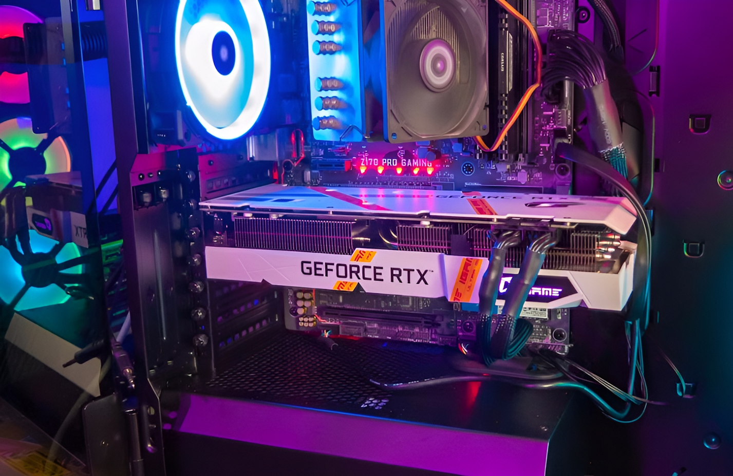 Una scheda grafica iGame GeForce RTX bianca installata all'interno di un case per PC da gioco illuminato RGB.