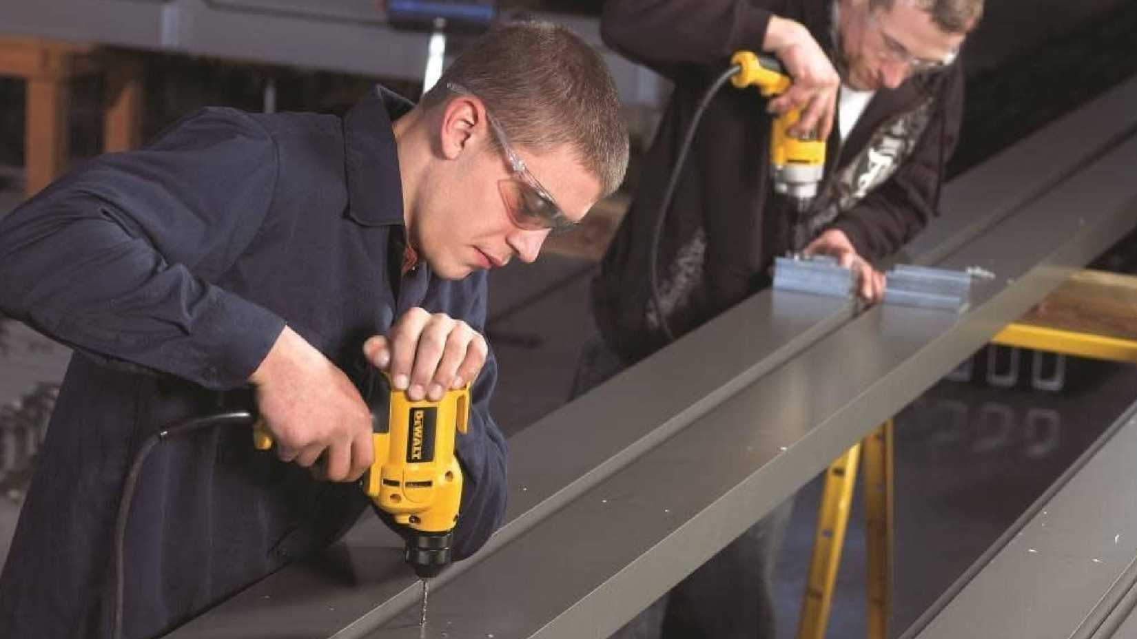 Uomini che usano trapani con cavo DEWALT