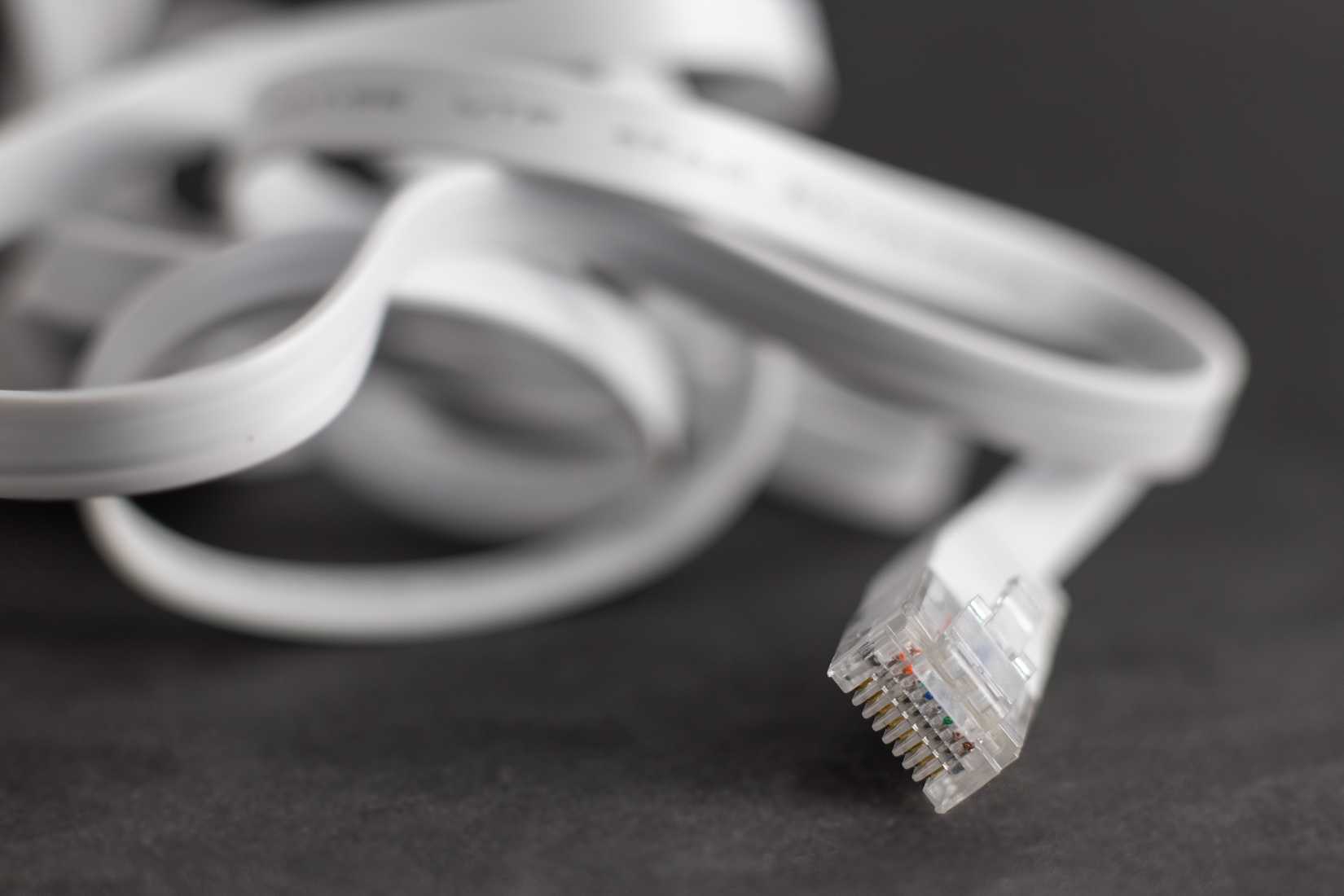 Un cavo Ethernet piatto appoggiato su una scrivania.