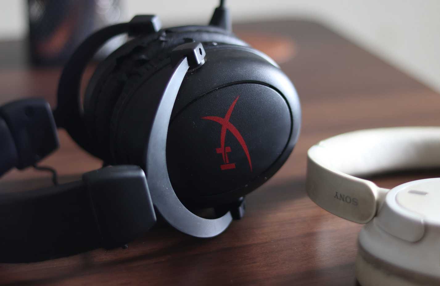 Cuffie HyperX e Sony su una scrivania. 