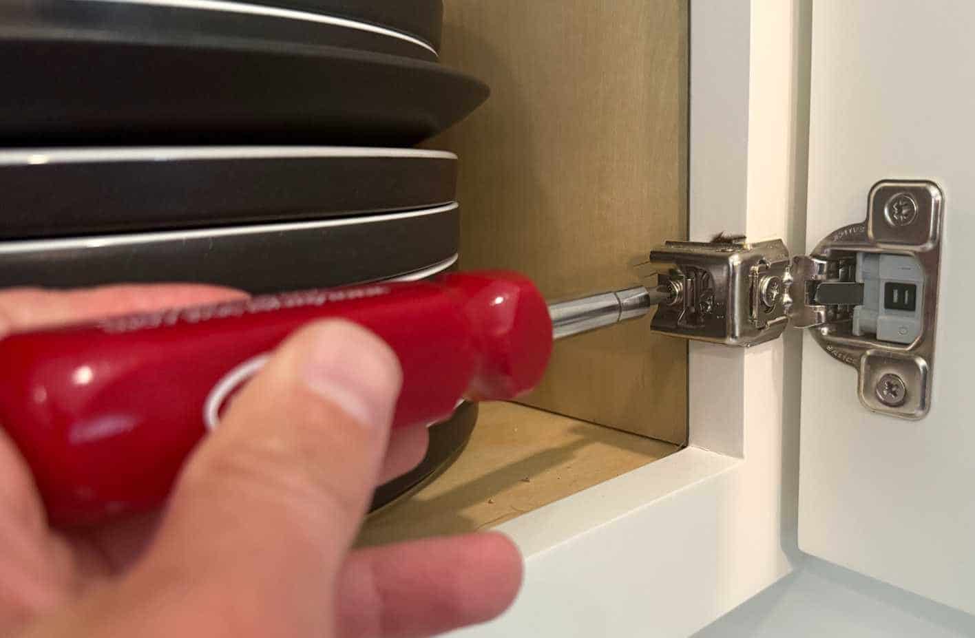 Rimozione della cerniera di un mobile con un cacciavite