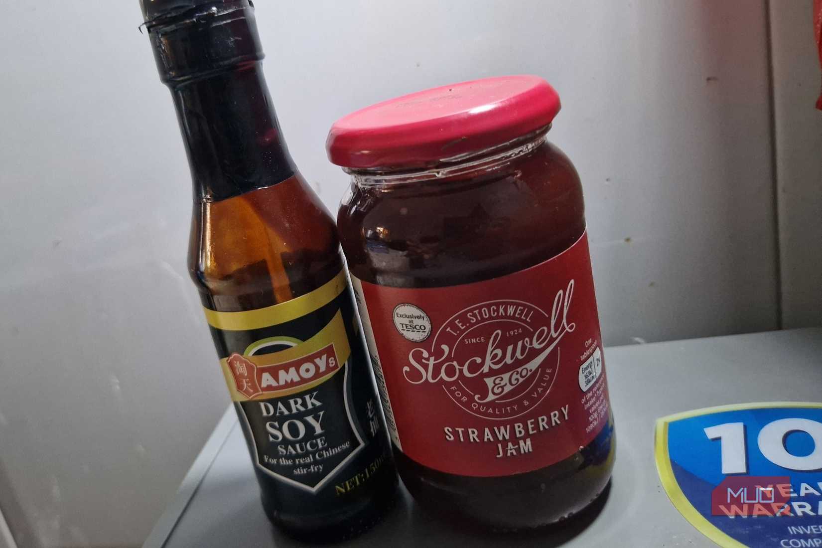 Barattoli di vetro per salsa di soia e marmellata di fragole nel congelatore.